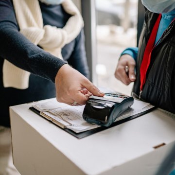 a person using a credit card tap pos system